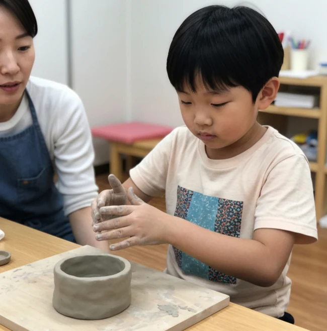 만든 점토 그릇 앞에서 손으로 점토를 빚는 아동